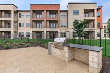 Outdoor grill area with stone countertop and prep space